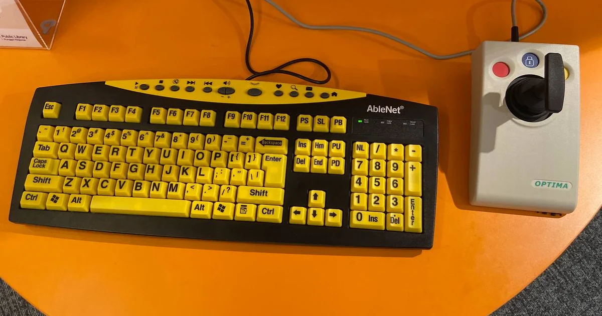 Assistive keyboard with large print, bright yellow keys. Joystick as an alternative mouse. Aids persons with visual impairment. Located in Punggol Regional Library as an accessibility feature.